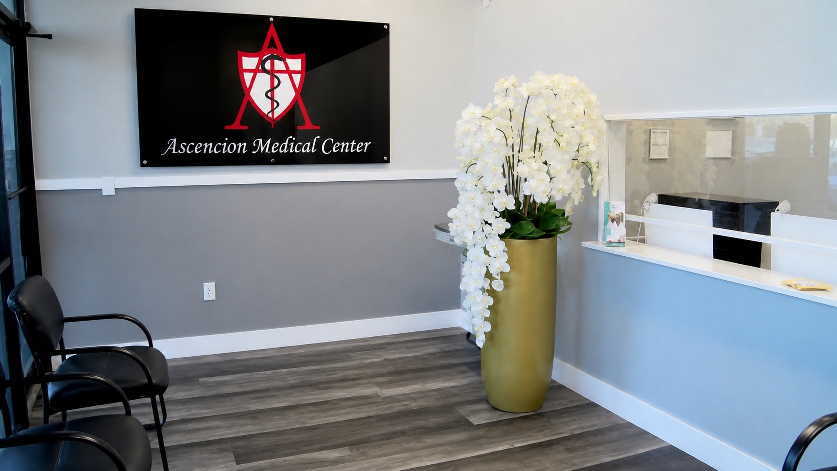 Ascencion Medical Center reception with the wall sign, orchids, and front desk.