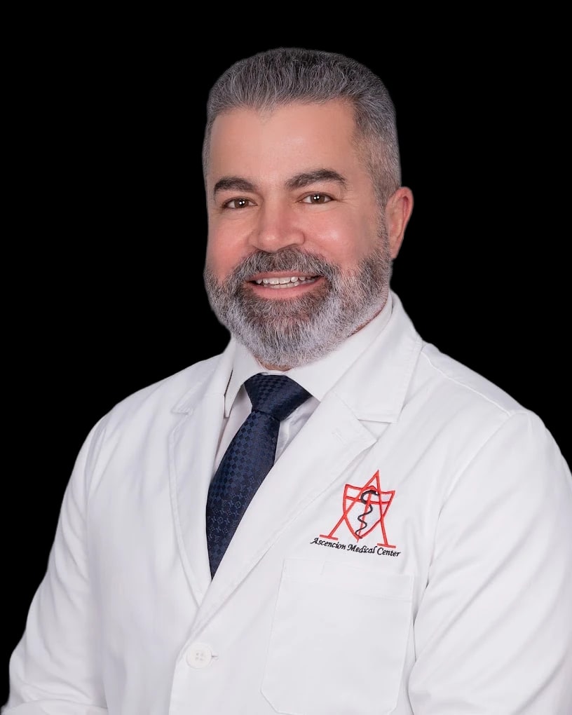 Guido Lopez smiles in a front-facing portrait wearing a white coat.
